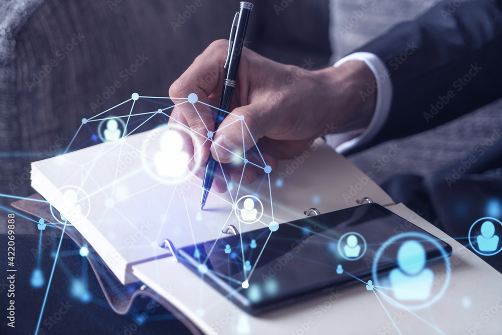 Obraz premium HR specialist is taking notes concerning new candidates to create international network in recruitment process. Checking social media connections in smartphone. Hologram icons. Formal suit