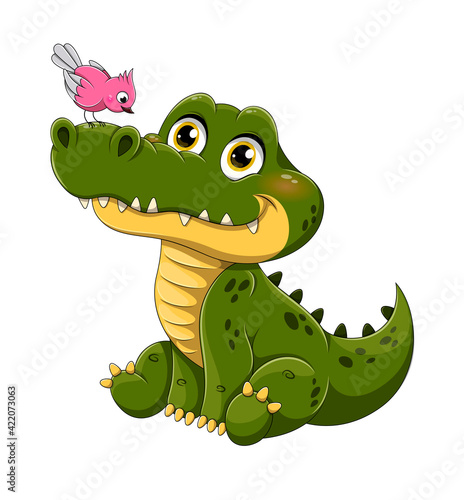 Adorable little green crocodile with bird perched on its nose