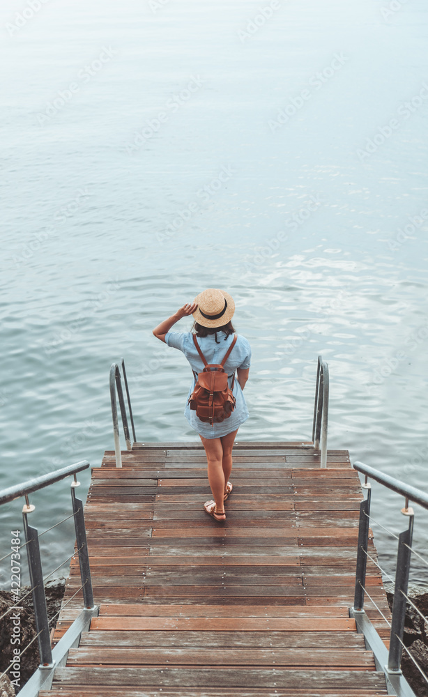 woman enjoying view of the sea walking by quay