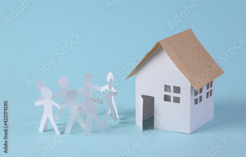 Chain of paper-cut people and house figurine. Unity, family concept