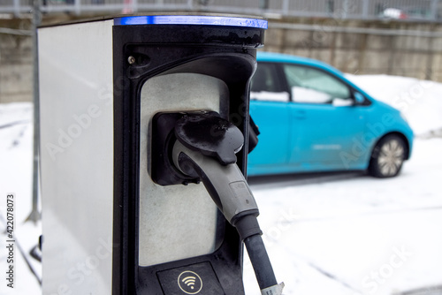 Electric car at the charging point. Green energy and zero emission theme. Sustainability and future of the nature and clean world. 