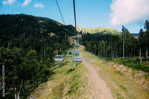 Cable car leading to the mountains around green nature.