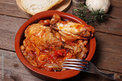 Delizioso pollo alla cacciatora in una ciotola su fondale di legno rustico. photo