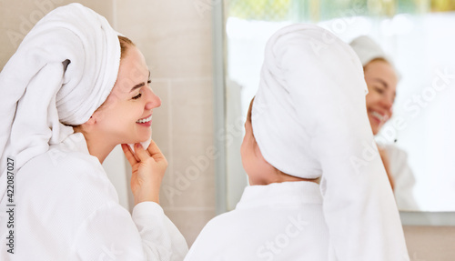 Smiling woman with daughter cleansing face skin