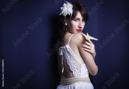Studio shot of young fashion model with dress with an open back

