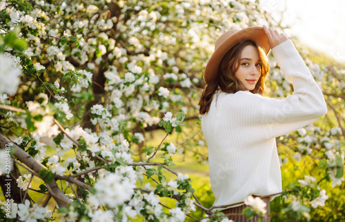 Beautiful young woman near blooming spring tree. Youth, love, fashion, romantic and lifestyle concept.