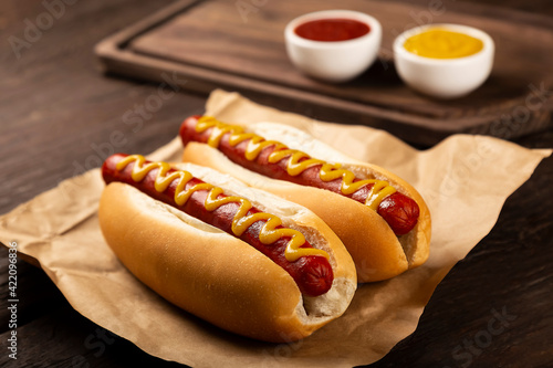 Murais de parede Hot dog with ketchup and yellow mustard.