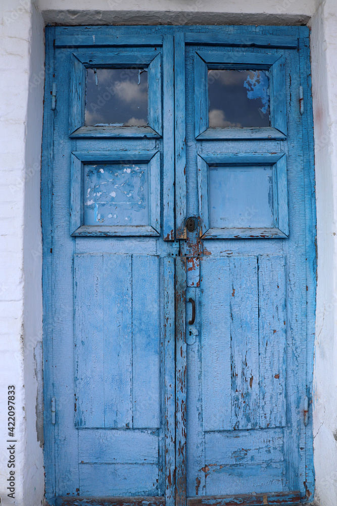 Old wooden door with lock painted in blue. Cracked weathered wooden texture. 