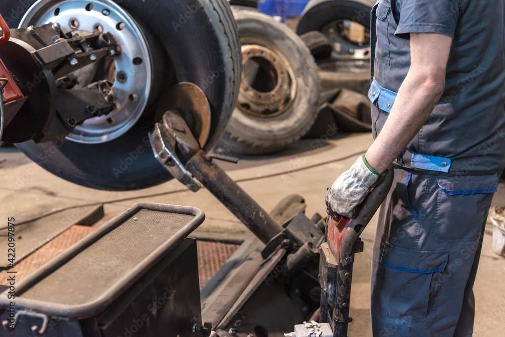 Tire workshop operator who uses a machine to mount or remove a truck wheel. Tire workshop operator who uses a machine to mount or remove a truck wheel.