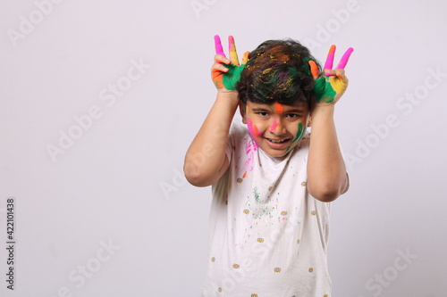 Concept for Indian festival. kid playing with colours or asian children celebrating holi - festival of colours