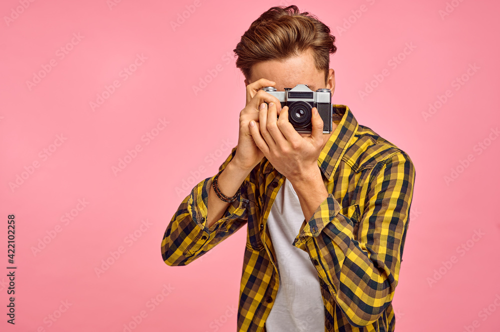 Young photographer with a camera, pink background Young photographer with a camera, pink background
