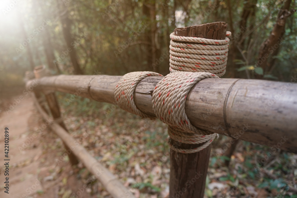 The fences or railings made of wood are stacked in the shape of a cross and tied with ropes. The fences or railings made of wood are stacked in the shape of a cross and tied with ropes.