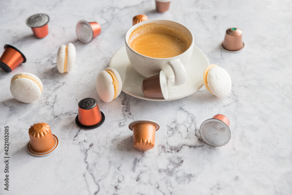 Cup of espresso, black coffee served with pods and capsules on marble table.Collection of espresso coffee capsules.Caffeine, hot drinks and objects concept.pods for coffee mashine Cup of espresso, black coffee served with pods and capsules on marble table.Collection of espresso coffee capsules.Caffeine, hot drinks and objects concept.pods for coffee mashine
