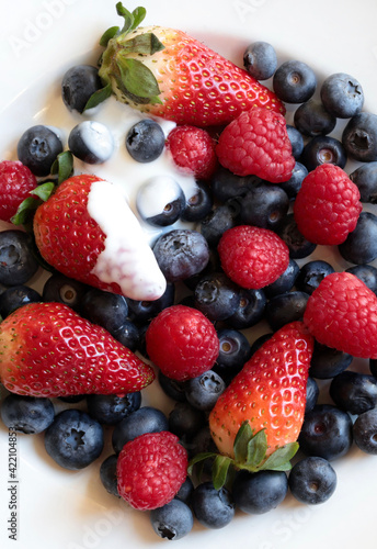 Frutta fresca. Lamponi  mirtilli e fragole freschi su un piatto bianco. Direttamente sopra.