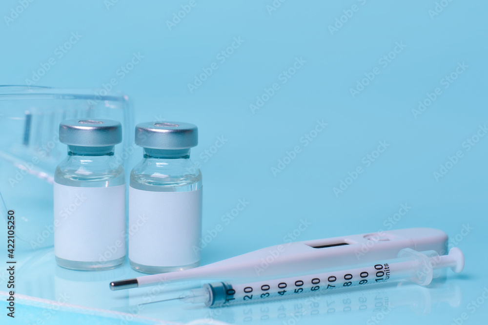 Medical bottles, vials,vaccine, syringe , face mask,body thermometer and protective glasses. The concept of medicine, healthcare, science.Coronavirus vaccine, mmunity improvement.Copy space for text. Medical bottles, vials,vaccine, syringe , face mask,body thermometer and protective glasses. The concept of medicine, healthcare, science.Coronavirus vaccine, mmunity improvement.Copy space for text.