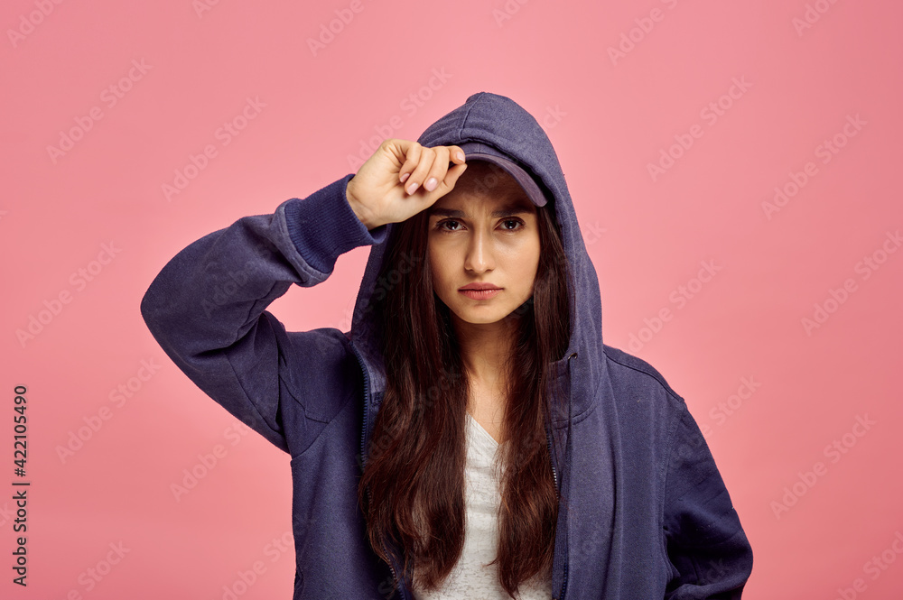 Young cute woman in hoodie, pink background Young cute woman in hoodie, pink background