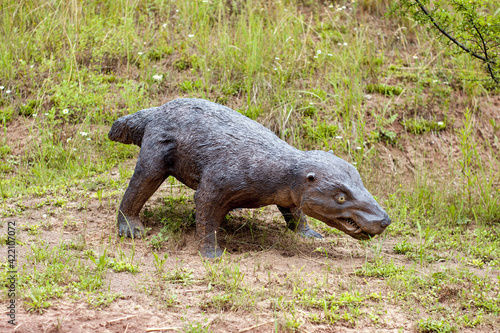 A model of a prehistoric dinosaur made available to visitors to a Jurassic park to learn about the history of many millions of years. In the background, vegetation and terrain resembling the natural h