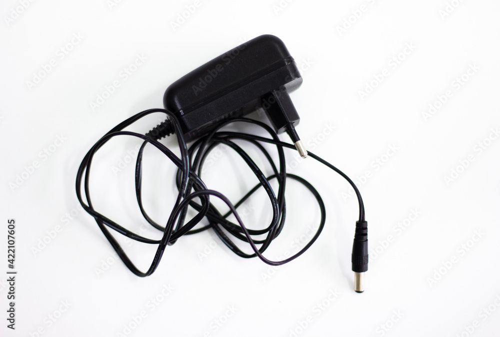 Black power adapter on white background. Charging adapter with cable. DC + 5 ~ 9V 5.5 * 2.1MM adapter on white background. Black power supply with cable on white background. Black power adapter on white background. Charging adapter with cable. DC + 5 ~ 9V 5.5 * 2.1MM adapter on white background. Black power supply with cable on white background.