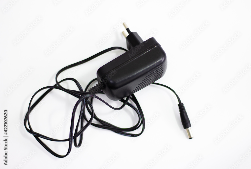 Black power adapter on white background. Charging adapter with cable. DC + 5 ~ 9V 5.5 * 2.1MM adapter on white background. Black power supply with cable on white background. Black power adapter on white background. Charging adapter with cable. DC + 5 ~ 9V 5.5 * 2.1MM adapter on white background. Black power supply with cable on white background.