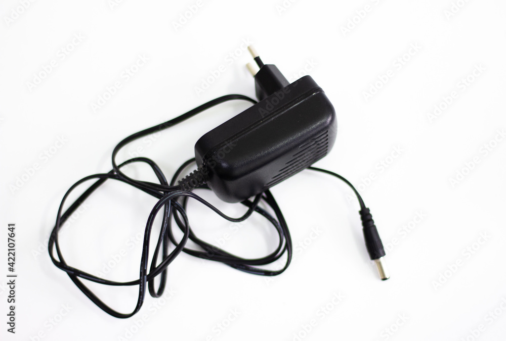 Black power adapter on white background. Charging adapter with cable. DC + 5 ~ 9V 5.5 * 2.1MM adapter on white background. Black power supply with cable on white background. Black power adapter on white background. Charging adapter with cable. DC + 5 ~ 9V 5.5 * 2.1MM adapter on white background. Black power supply with cable on white background.