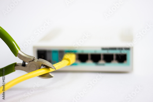 Network cable is plugged into router. Yellow cable in Wi-Fi router. White router with power cord. Router rear view with connections.