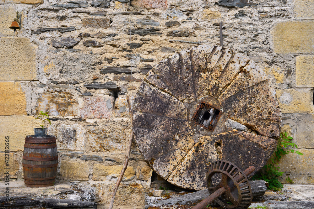 La vieille meule et le vieux tonneau sur un vieux mur en pierres