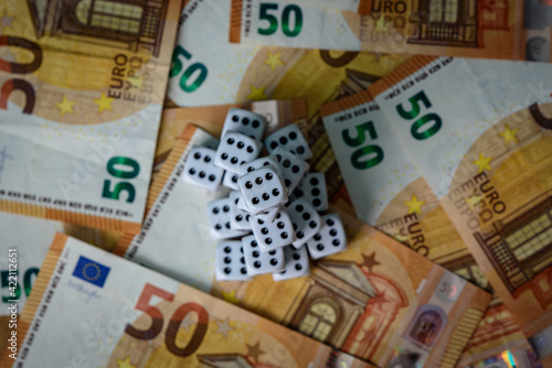 several white dice and euro money