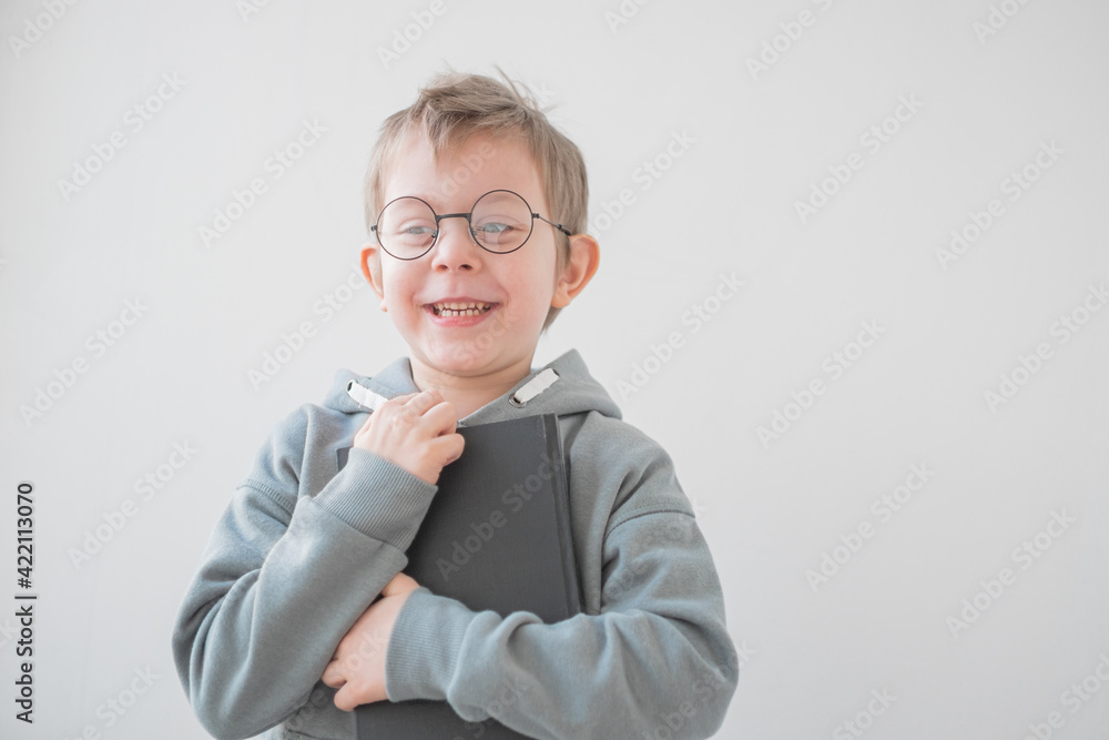 Cute Cheerful Little boy reading a book in glasses. Smart preschooler. Back to school concept Cute Cheerful Little boy reading a book in glasses. Smart preschooler. Back to school concept