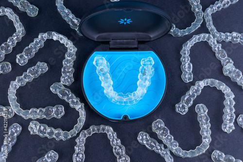 Plastic case with invisible transparent orthodontic retainers invisalign on black background Fotobehang