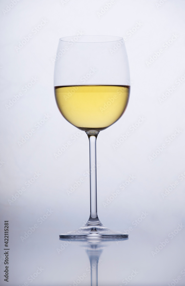 White wine in a glass on grey background