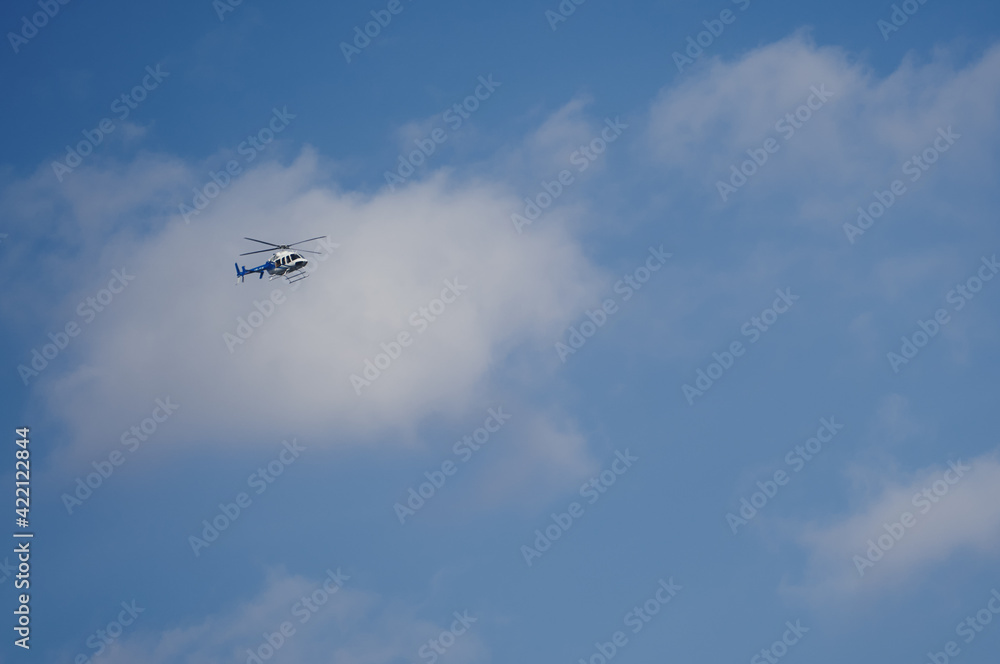 Helicopter against a bluaerial, propeller, power, speed, white, copter, technology, machine, high, clouds, sky, helicopter, blue, fly, air, chopper, flight, landing, plane, travel, ae sky with clouds. Helicopter against a bluaerial, propeller, power, speed, white, copter, technology, machine, high, clouds, sky, helicopter, blue, fly, air, chopper, flight, landing, plane, travel, ae sky with clouds.