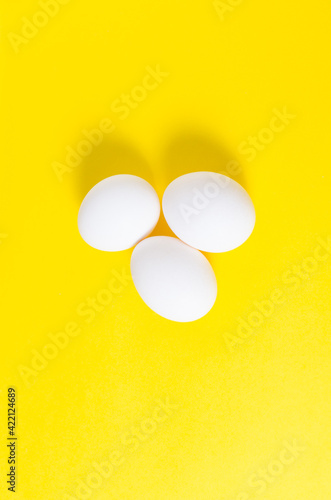 three chicken eggs lie on a yellow background. preparing for Easter