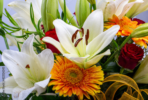 Tela A beautiful bouquet of white lilies and orange gerberas