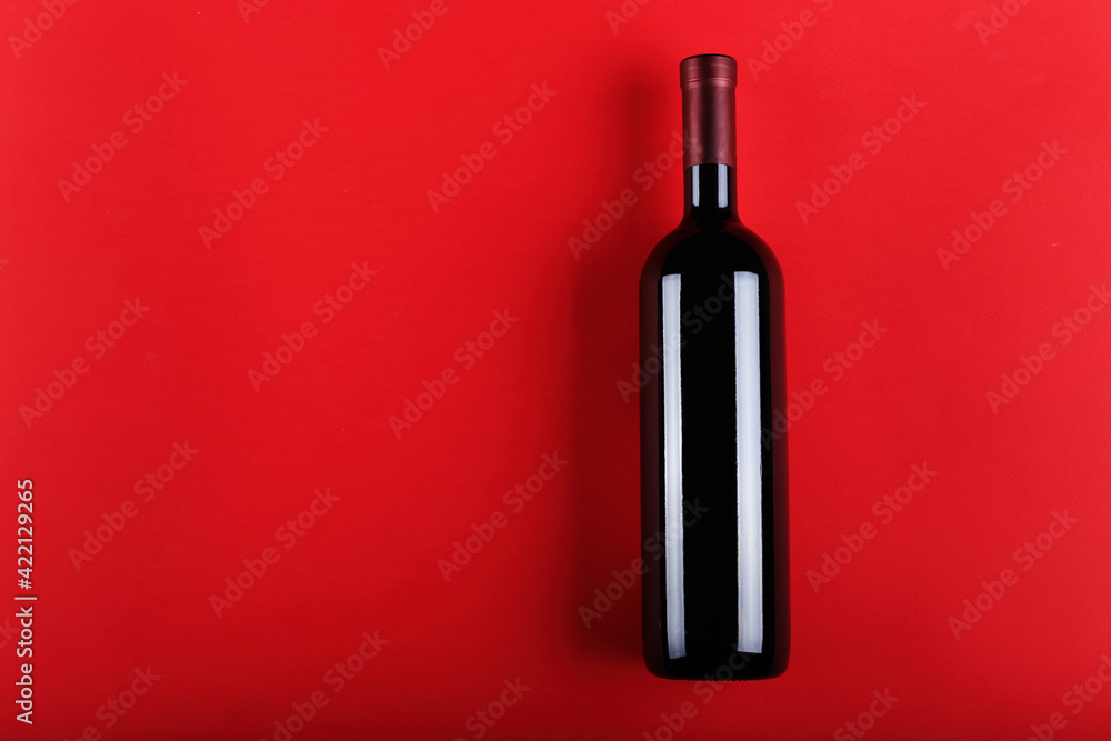Wine bottle on a red paper background. Space for text. Top view. Wine bottle on a red paper background. Space for text. Top view.