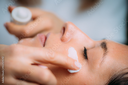 Cosmetician Applying Cream on Woman   s Face