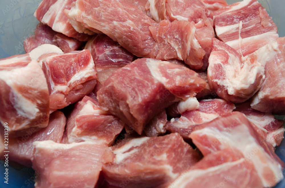 Raw pork, cut into small cubes in plates and ready to marinate. Close-up