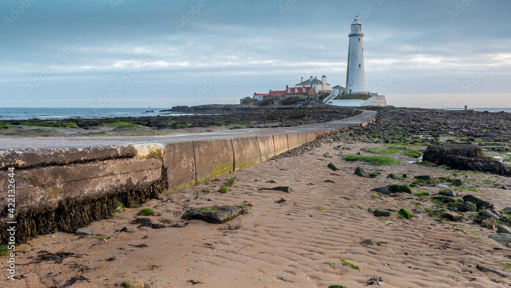 Whitley Bay on the north east coast of England, UK. Looking towards St Marys Lighthouse over the causeway on an overcast morning at dawn.