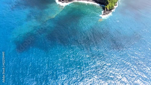 Reveal Drone Shot of Cliff and Jungle Coast Surrounded by Ocean on Island of Maui, Hawaii. photo