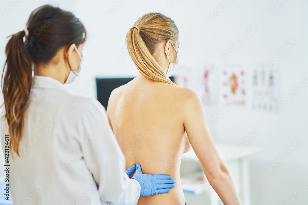 Doctor in mask checking up breast to her patient Doctor in mask checking up breast to her patient