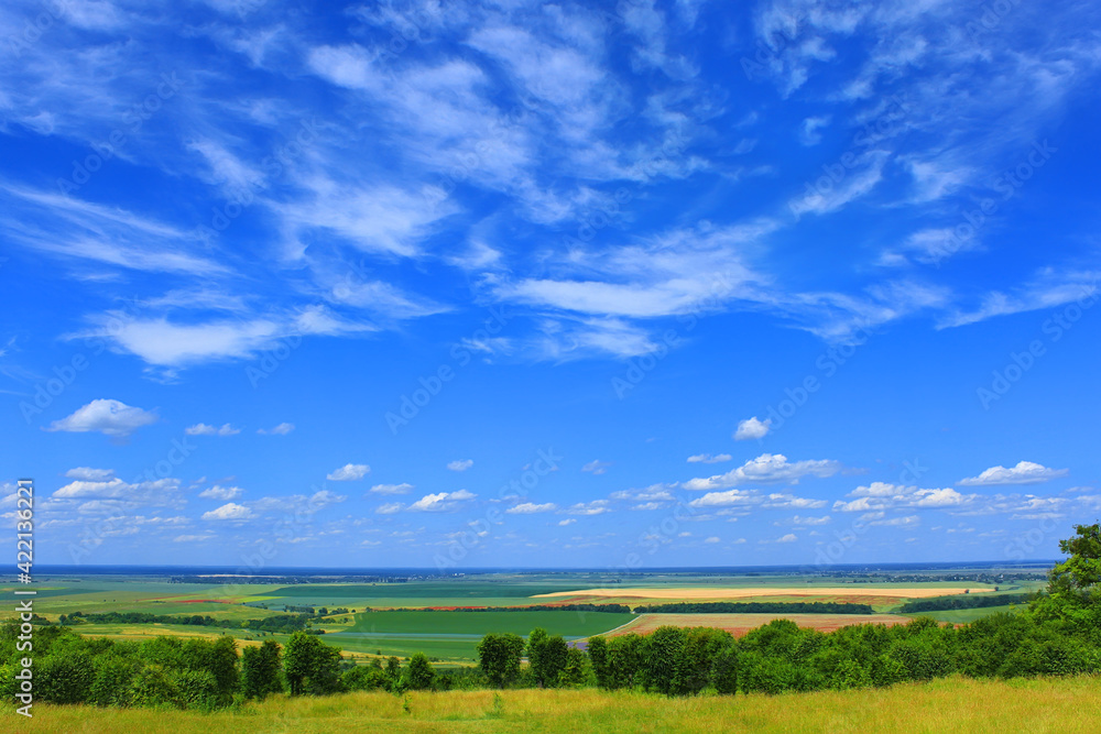 Picturesque summer cloudscape over fields, meadows, forests, roads, villages and settlements on far background