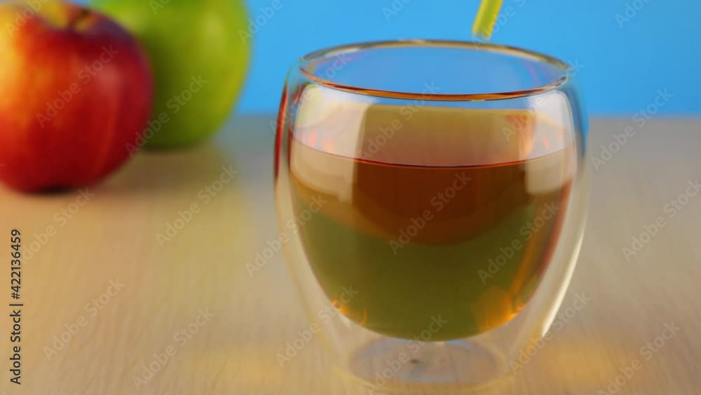 Drinking straw from a glass of apple juice. Glass of fresh apple juice close-up. Homemade fruit juice on table. Organic vitamin drink. Drinking straw from a glass of apple juice. Glass of fresh apple juice close-up. Homemade fruit juice on table. Organic vitamin drink.