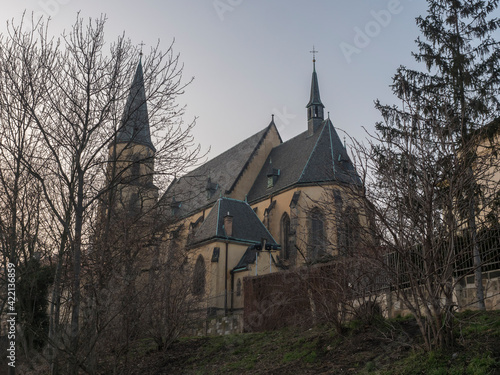 View of gothic church of saint Apolinar in czech Kostel sv. Apolinare with bare trees at old Prague center