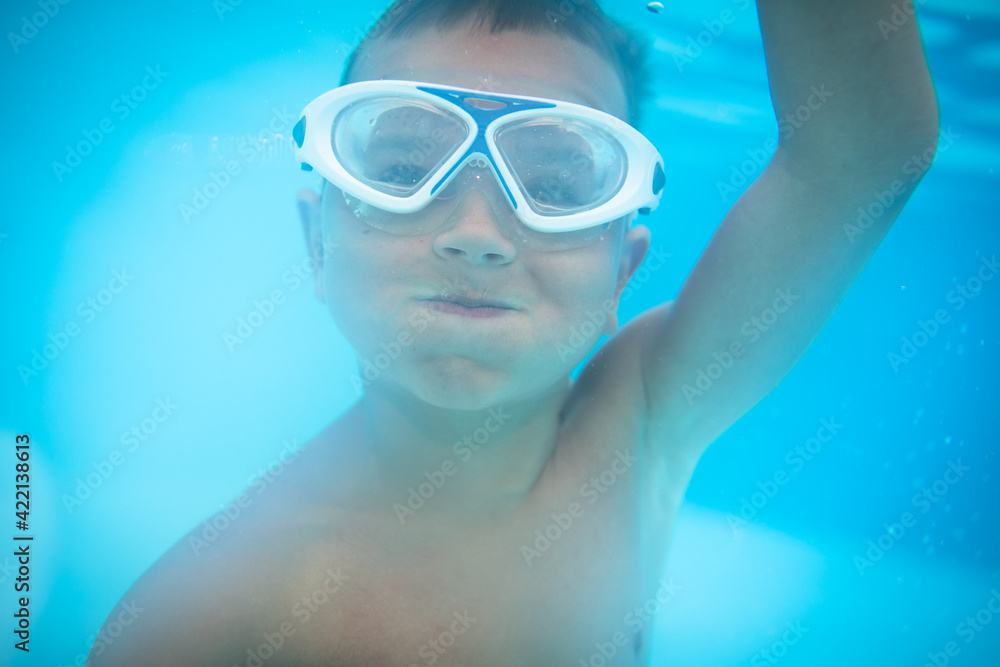 Naklejka premium Cute little boy in a swimming pool