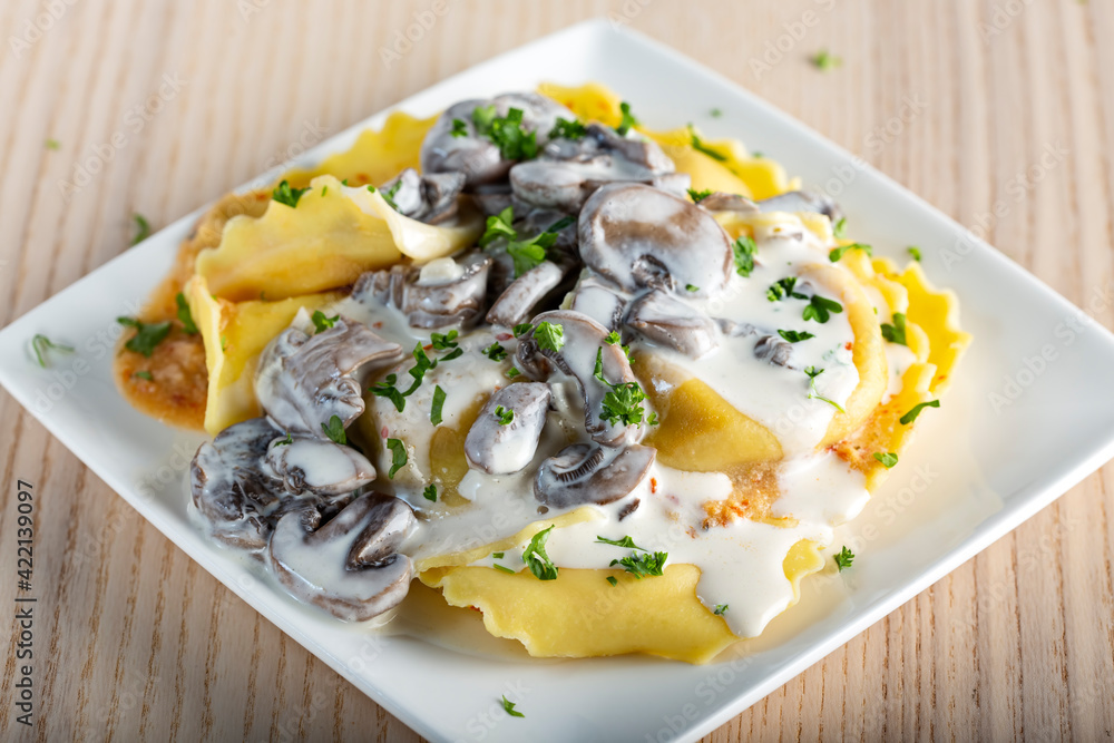 Ravioli filled with mozzarella cheese and red pepper with cream and mushrooms sauce Ravioli filled with mozzarella cheese and red pepper with cream and mushrooms sauce