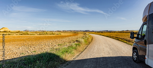 Wohnmobil auf einer Staubstrasse in Wüstenlandsschaft