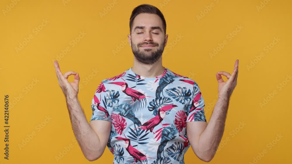Spiritual bearded young man 20s in basic casual summer t-shirt isolated on yellow background in studio. People lifestyle concept. Hold spreading hands in yoga gesture relax meditate try to calm down Spiritual bearded young man 20s in basic casual summer t-shirt isolated on yellow background in studio. People lifestyle concept. Hold spreading hands in yoga gesture relax meditate try to calm down