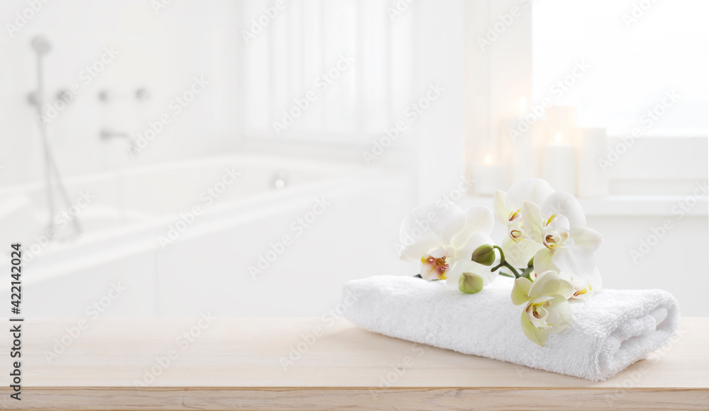 Towel and orchid flowers on wooden table with copy space Towel and orchid flowers on wooden table with copy space