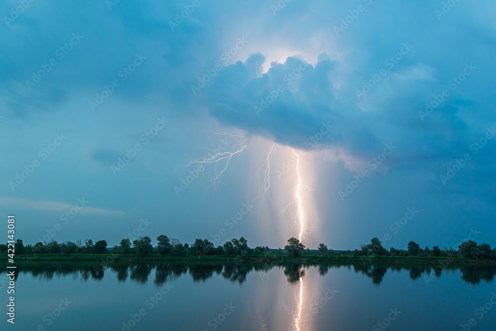 Bright flash of lightning over the river