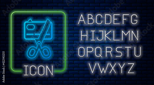 Glowing neon Scissors cutting a credit card icon isolated on brick wall background. Online payment. Cash withdrawal. Financial operations. Shopping sign. Neon light alphabet. Vector