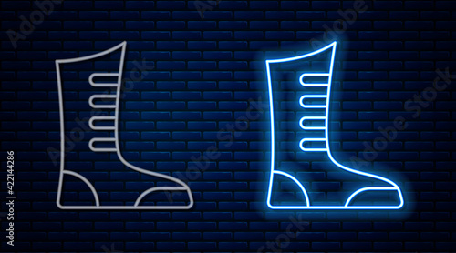 Glowing neon line Sport boxing shoes icon isolated on brick wall background. Wrestling shoes. Vector